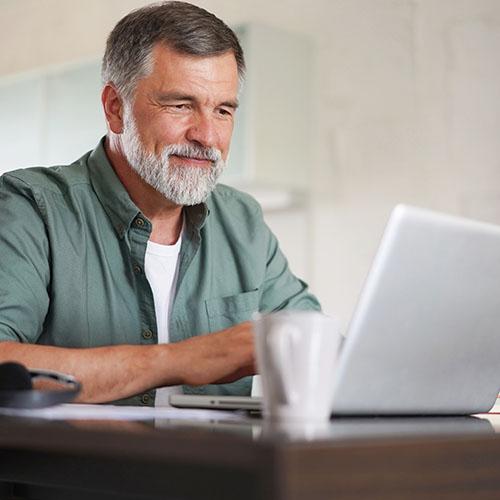 A man looks at his laptop.